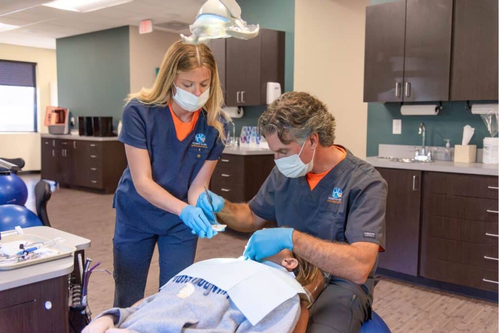 Holbert-orthodontics-why-choose-us Why choose us homepage doctor working with hygienist